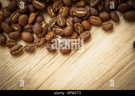 Les grains de café sur un bureau en bois éclairé par une lumière chaude (shallow DOF (tons de couleur libre) Banque D'Images