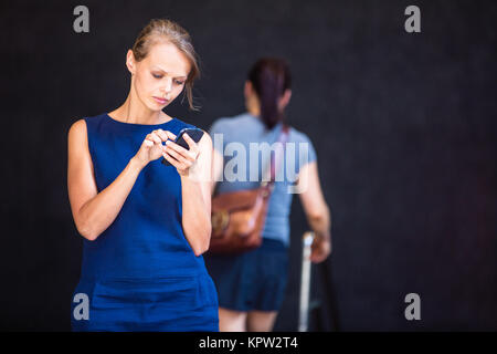 Jolie jeune businesswoman talking on the phone en face d'un immeuble moderne à Manhattan (shallow DOF (tons de couleur libre) Banque D'Images