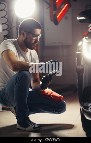 L'homme vérifie le polissage avec une torche Banque D'Images