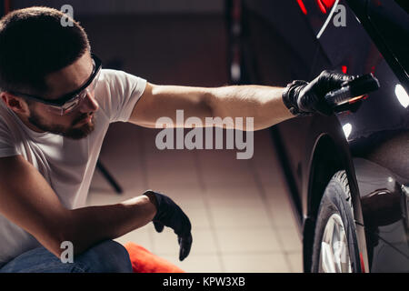 L'homme vérifie le polissage avec une torche Banque D'Images