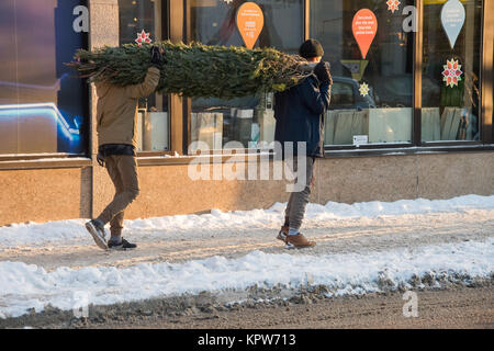 Montréal, Canada - 16 décembre 2017 : deux hommes sont porteurs d'un arbre de Noël Banque D'Images