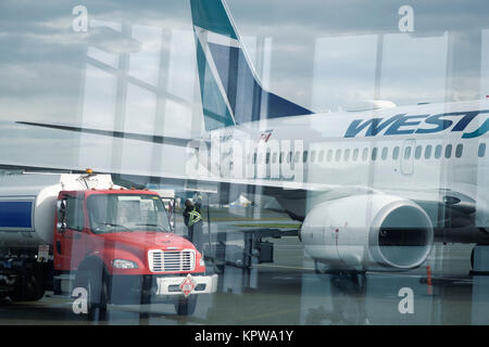 La photo artistique de camion-citerne de carburant avion WestJet ravitaillement voie avant un vol à l'aéroport international de Victoria, BC, Canada 2017 Banque D'Images