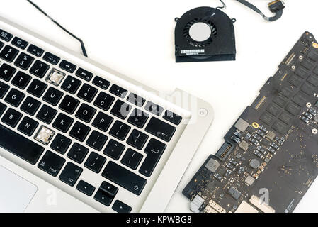 Composants cassés d'un macbook Apple ipad ordinateur sur un fond blanc avec un copyspace pour ordinateur idées de conception de réparation Banque D'Images
