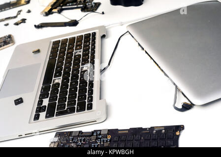 Composants cassés d'un macbook Apple ipad ordinateur sur un fond blanc avec un copyspace pour ordinateur idées de conception de réparation Banque D'Images