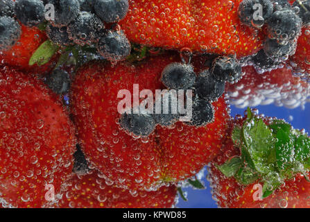 Les bleuets et les fraises dans l'eau Banque D'Images