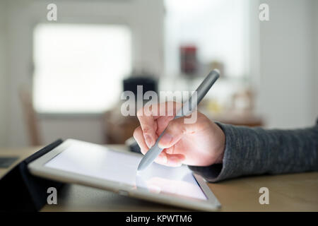 Femme à l'aide de rédaction de plume sur tablette Banque D'Images