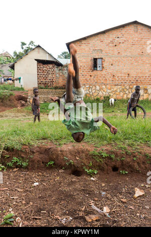 Lugazi, en Ouganda. 18 juin 2017. Un garçon ougandais faisant une bascule dans l'air. Banque D'Images