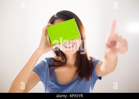 Femme portant avec dispositif de VR et de pointer du doigt sur l'air Banque D'Images