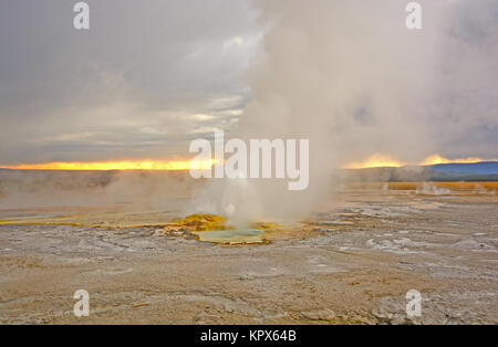 L'éruption du geyser au coucher du soleil Banque D'Images