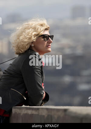 Belle blonde femme avec les cheveux bouclés est à la recherche dans la distance Banque D'Images