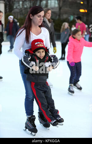 Chicago, USA. Déc 16, 2017. Une mère enseigne à son fils à patiner à la patinoire McCormick Tribune dans le Millennium Park, Chicago, États-Unis, le 16 décembre 2017. La patinoire en plein air dans le Parc du Millénaire s'ouvre au public du 17 novembre 2017 au 4 mars 2018, si le temps le permet. Credit : Wang Ping/Xinhua/Alamy Live News Banque D'Images