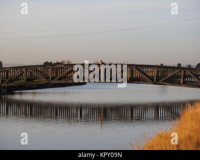 Sheerness, Kent, UK. Dec 18, 2017. Météo France : un matin ensoleillé (temp 4c à 9h00). Un cycliste traverse le pont sur le canal des lignes défensives de Sheerness. Credit : James Bell/Alamy Live News Banque D'Images