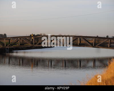 Sheerness, Kent, UK. Dec 18, 2017. Météo France : un matin ensoleillé (temp 4c à 9h00). Un cycliste traverse le pont sur le canal des lignes défensives de Sheerness. Credit : James Bell/Alamy Live News Banque D'Images