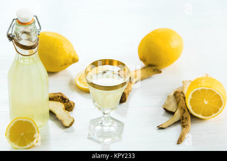 Accueil teinture de Gingembre dans un verre et de citrons frais sur le fond en bois blanc Banque D'Images