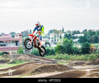 L'racer sur une moto participe à une course de motocross, saute sur un tremplin. Il a décollé en haut d'une moto. Sport dangereux Banque D'Images