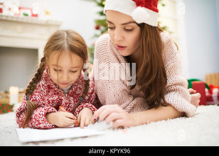 Aider ma petite fille avec décoration de Noël Banque D'Images