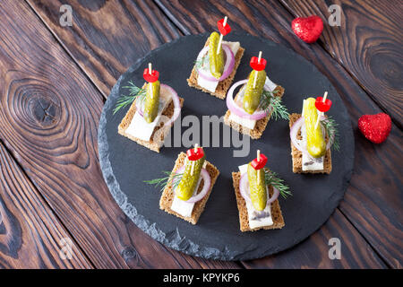 Les canapés avec le pain de seigle, le hareng et les cornichons sur une table de fête. Valentine's day concept ou mariage. Banque D'Images