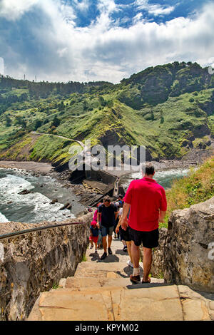 SAN JUAN DE GAZTELUGATXE, ESPAGNE - 4 juillet 2016 : les touristes aller sur une pierre de bain en amont. Une longue échelle à une chapelle, un soleil d'été, dans la distance mo Banque D'Images