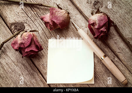 Roses anciennes et sticky note vierge Banque D'Images