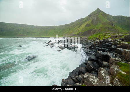 La Chaussée des Géants avec des vagues d'écrasement sur la célèbre colonnes de basalte, le résultat d'une ancienne éruption volcanique. Le comté d'Antrim, sur la côte nord de Banque D'Images