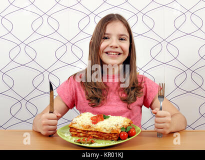 Happy little girl avec la lasagne sur table Banque D'Images