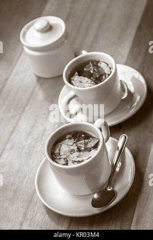 Tasses de thé de coca et le sucre sur la table en bois Banque D'Images