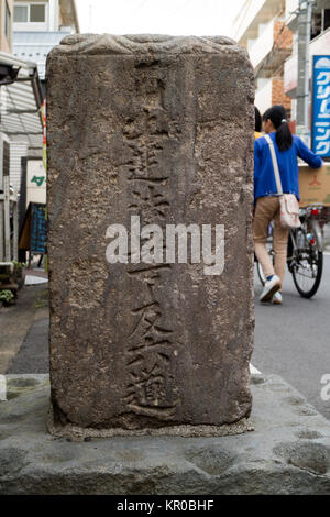 Tokyo - Japon, le 15 mai 2017 : Pierre avec un enseignement bouddhiste sculpté en elle au coin d'une rue à Tokyo Banque D'Images