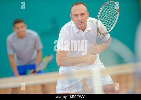 Les hommes jouant au tennis en double Banque D'Images