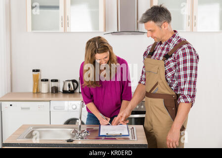 Femme et Homme Plombier Facture Signature Banque D'Images