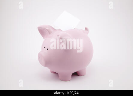 Pink piggy bank et feuille de papier vierge avec copyspace de message texte Banque D'Images