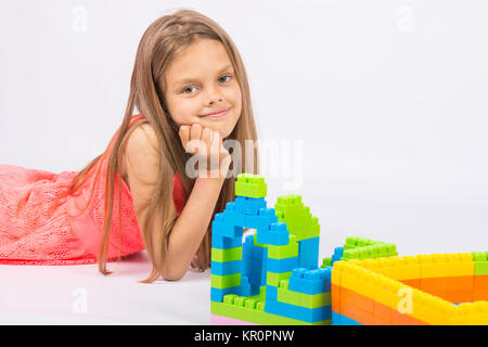 Fille de 7 ans construit une maison du bloc, designer et réfléchie et fun ressemble dans le cadre Banque D'Images