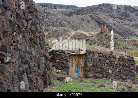 Maisons en pierre du village de Kilittas à Kars, Turquie, sur la frontière turque et arménienne. Le minaret blanc est en Turquie et l'église en Arménie. Banque D'Images