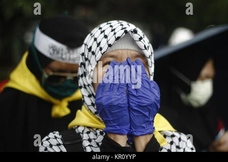 Jakarta, Indonésie. 25Th Dec 2017. Les activistes musulmans indonésiens wearing scarf et offrant prier au cours d'une manifestation tenue à montrer l'opposition au Président américain Donald J. Trump a décidé de reconnaître Jérusalem comme capitale d'Israël, à Jakarta, Indonésie, 17 décembre 2017.Des milliers de manifestants musulmans indonésiens dirigé par le Conseil des oulémas indonésiens ont continué de rassemblements contre le président américain, Donald J ressens Atouts de Jérusalem capitale d'Israël et s'installera à l'ambassade américaine de Tel Aviv à Jérusalem. Credit : Risa/Krisadhi Pacific Press/Alamy Live News Banque D'Images