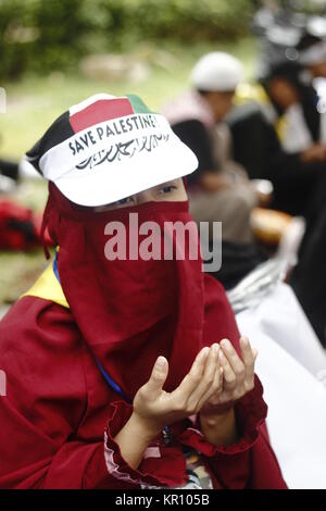 Jakarta, Indonésie. 25Th Dec 2017. Les activistes musulmans indonésiens wearing scarf et offrant prier au cours d'une manifestation tenue à montrer l'opposition au Président américain Donald J. Trump a décidé de reconnaître Jérusalem comme capitale d'Israël, à Jakarta, Indonésie, 17 décembre 2017.Des milliers de manifestants musulmans indonésiens dirigé par le Conseil des oulémas indonésiens ont continué de rassemblements contre le président américain, Donald J ressens Atouts de Jérusalem capitale d'Israël et s'installera à l'ambassade américaine de Tel Aviv à Jérusalem. Credit : Risa/Krisadhi Pacific Press/Alamy Live News Banque D'Images