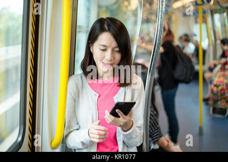Femme l'utilisation de téléphone mobile en train Banque D'Images