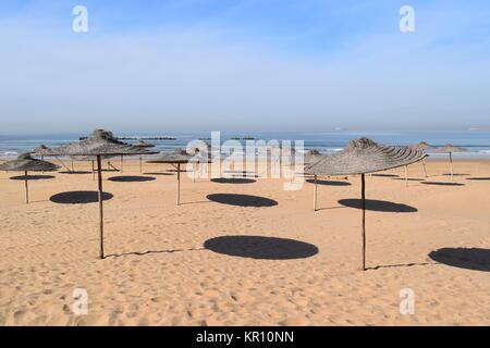 Des parasols sur la plage de jeter l'ombre circulaire dans le sable Banque D'Images