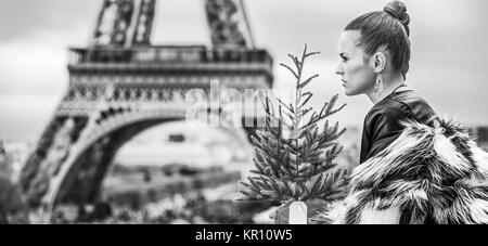 La saison des festivals à Paris. femme très tendance avec arbre de Noël en manteau de fourrure dans l'avant de la tour Eiffel à Paris, France à la recherche dans la distance Banque D'Images