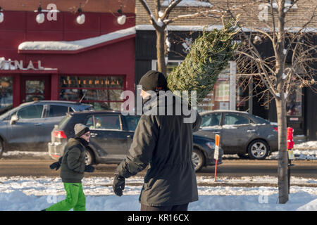 Montréal, Canada - 16 décembre 2017 : un homme porte un arbre de Noël Banque D'Images