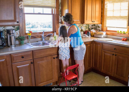 Grand-mère et petite-fille lave-légumes dans la cuisine Banque D'Images