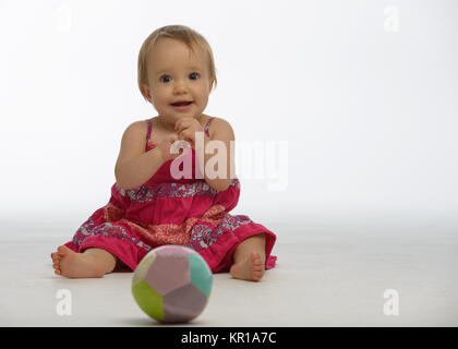 Bébé fille jouant avec une balle jouet Banque D'Images