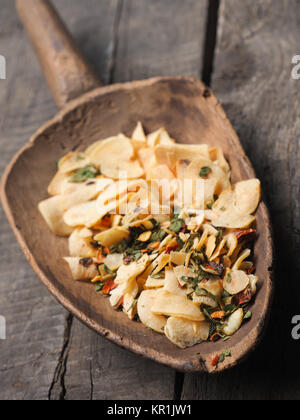 Pelle en bois ancien utilisé avec l'ail et fines herbes séchées ingrédients de cuisine épicée, concept de droit Banque D'Images