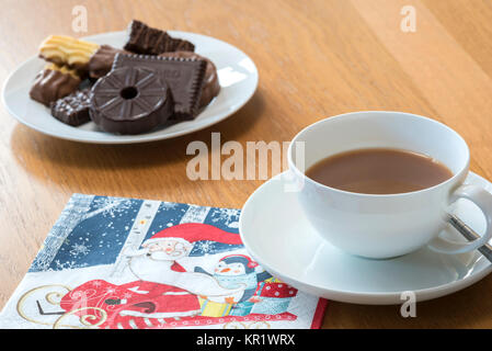 Tasse de thé avec des biscuits chocloate avec festive serviette. Banque D'Images