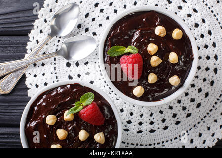 Délicieux chocolat au lait aux noisettes et framboises close-up dans un bol sur la table. haut horizontale Vue de dessus Banque D'Images