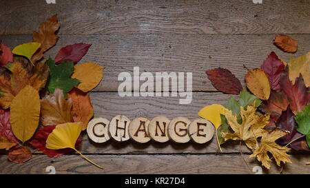 Changement de feuilles colorées sur des planches en bois avec le mot CHANGE Banque D'Images
