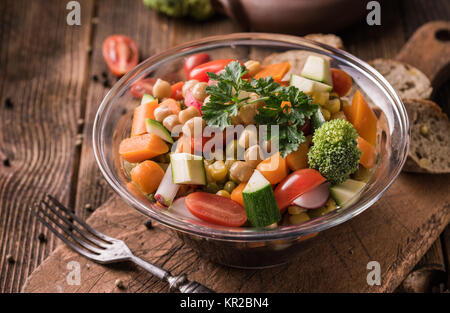 Dans une salade de légumes bol en verre avec le brocoli et les tomates sur la table en bois sombre. Banque D'Images