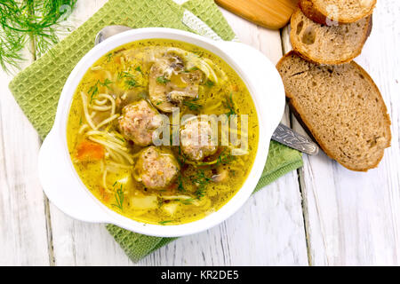 Soupe avec des boulettes de viande et les nouilles dans un bol sur nappes top Banque D'Images