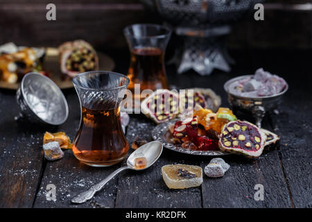 Du thé turc avec d'authentiques tasses en verre. Deux tasses de thé turc et des confiseries à base de bois sombre Banque D'Images