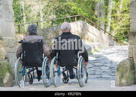 Couple de personnes âgées sur leur fauteuil roulant Banque D'Images