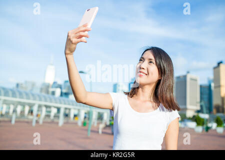 Prendre femme par téléphone mobile selfies Banque D'Images