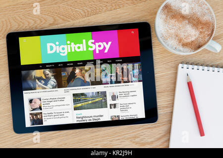 Le site Digital Spy sur un iPad tablet device qui repose sur une table en bois à côté d'un bloc-notes et un crayon et une tasse de café (rédaction uniquement) Banque D'Images